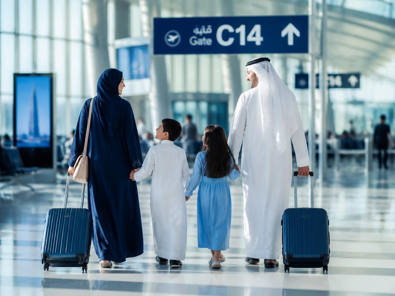 A family walking through an airport terminal toward their gate